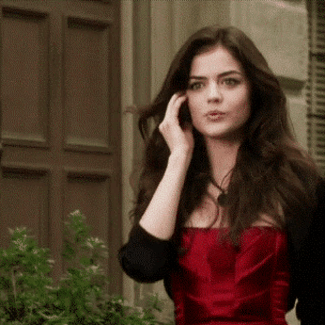a woman in a red dress is talking on her cell phone
