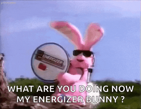 a pink bunny is wearing sunglasses and holding a microphone and a battery .