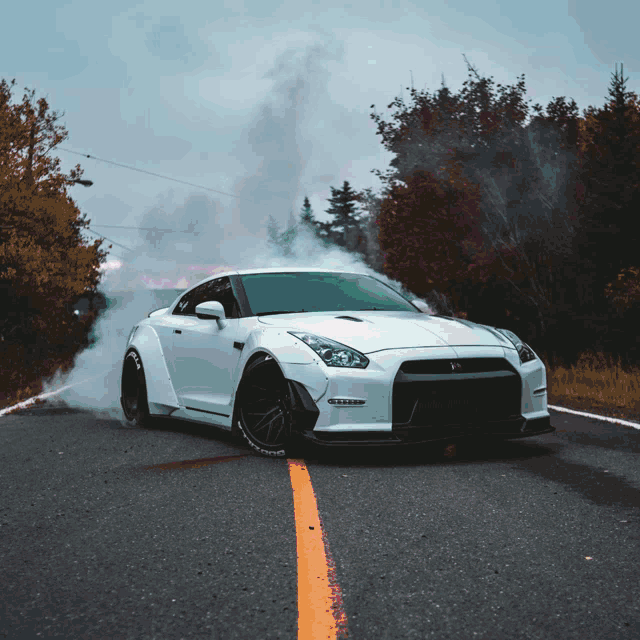 a white sports car with smoke coming out of the hood