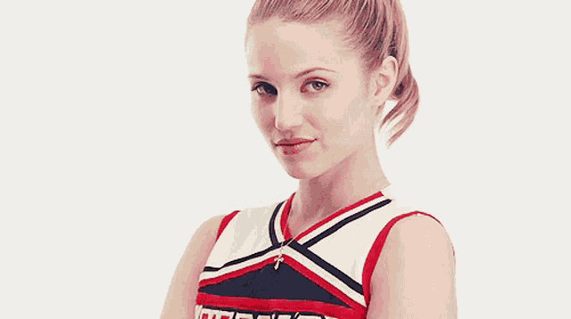 a cheerleader wearing a red white and blue uniform with the letter t on the front