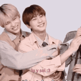 a group of young men are hugging each other and smiling while standing next to each other .