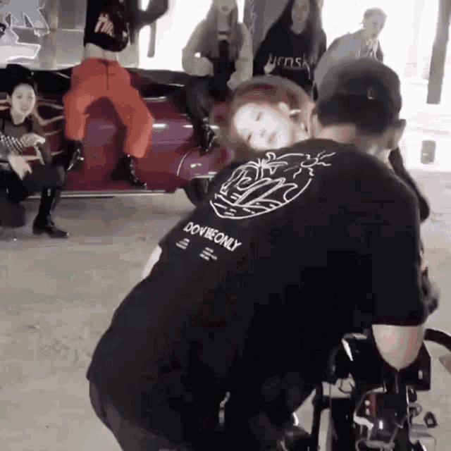 a man wearing a black shirt that says ' do it only ' on the back