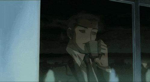 a man in a suit is drinking from a cup
