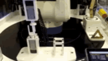 a blurred image of a machine with a yellow triangle in the corner