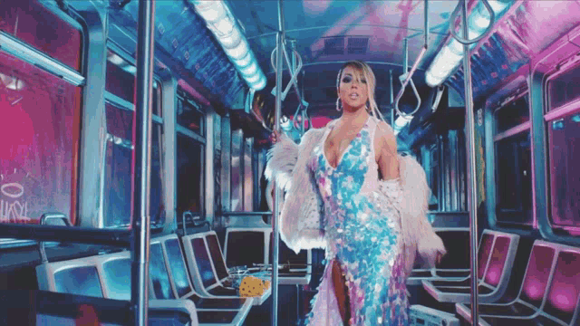 a woman in a blue dress is standing on a subway train