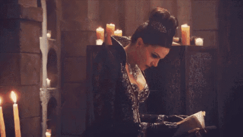 a woman wearing a necklace and a black coat is smiling .