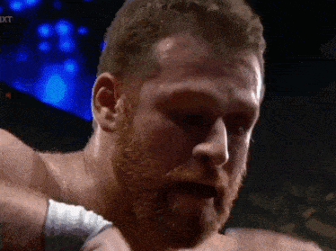 a close up of a man 's face with the word nxt on the bottom left