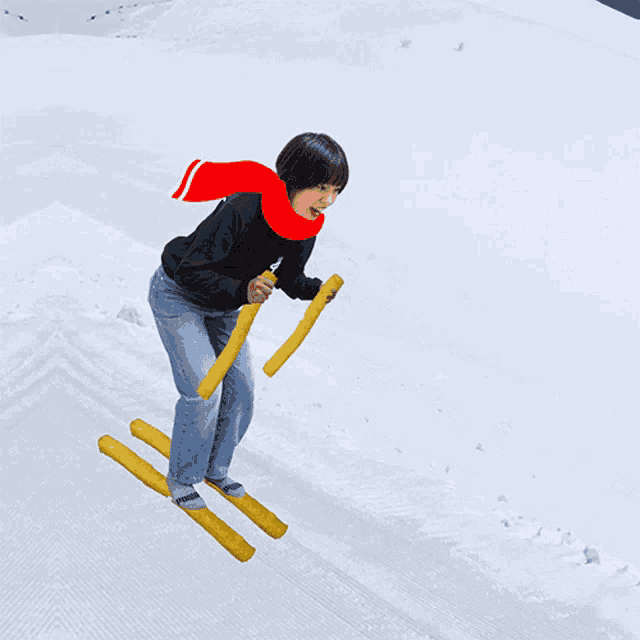 a girl wearing a red scarf is skiing down a snowy hill
