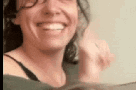 a close up of a woman wearing glasses smiling while looking at something .