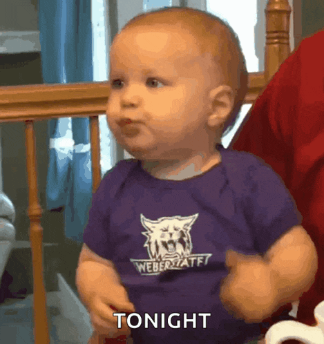 a baby wearing a purple weber state shirt