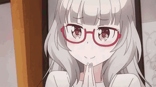a girl wearing glasses and a white shirt is smiling .