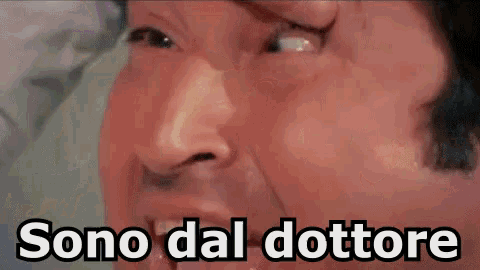 a close up of a man 's face with the words sono dal dottore written below it .