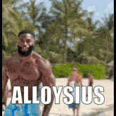 a shirtless man with a beard is standing on a beach with the words alloysius written on it .