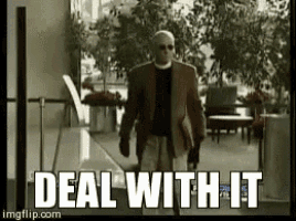 a man in a suit and sunglasses is walking in a hallway with the words deal with it written below him