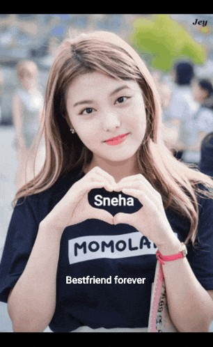 a girl wearing a momola shirt making a heart shape with her hands