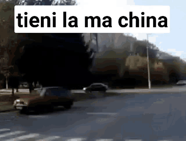 a red car is driving down a street with the words " tieni la ma china " above it .