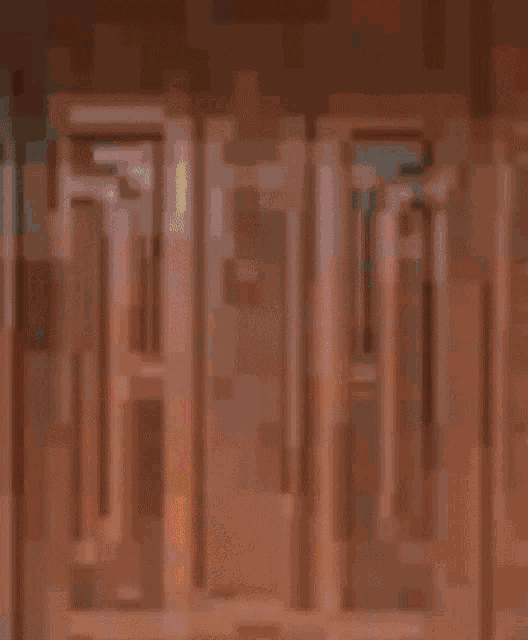 a blurry picture of a wooden door with a green object in the background