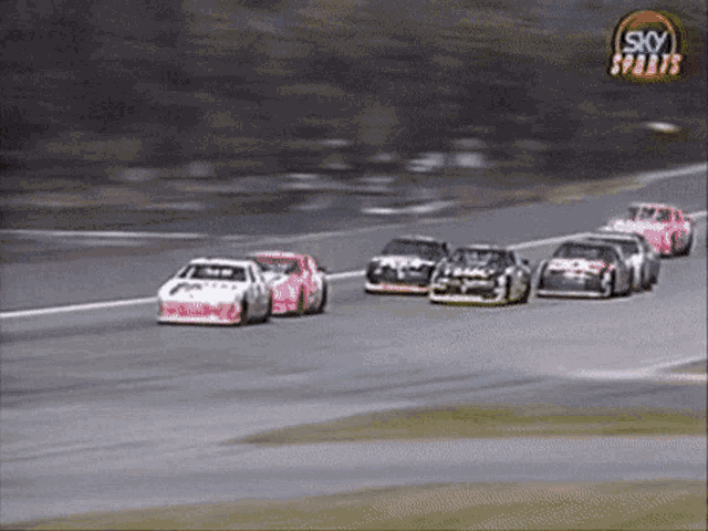 a group of race cars are racing on a track with a sky sports logo in the background