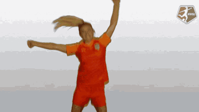 a female soccer player jumps in the air with her arms outstretched