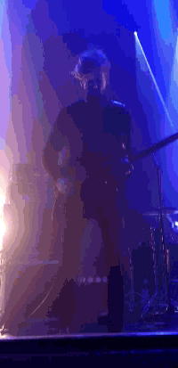 a person is playing a piano in a dark room with blue lights