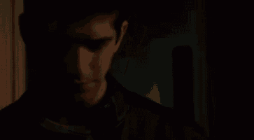a close up of a man 's face with red eyes in the dark .