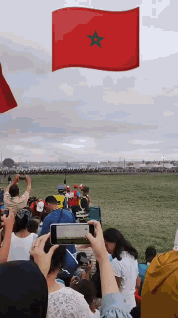 a flag with a green star is flying in the air above a crowd