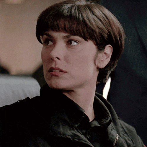 a close up of a woman 's face with a serious look on her face