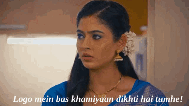 a woman with a flower in her hair and the words logo mein bas khamiyaan dikhti hai tumhe below her