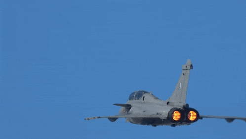 a fighter jet with the number 1 on the tail is flying through a blue sky