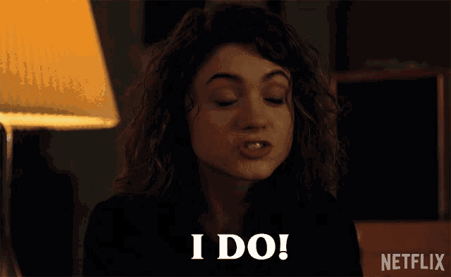 a woman with curly hair says i do in front of a netflix logo
