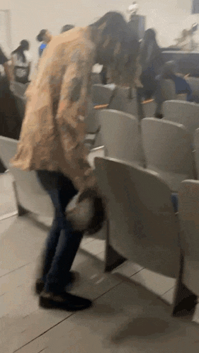 a blurry picture of a person standing in a row of seats