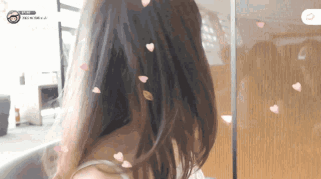 a woman 's back is shown with hearts coming out of her hair and a sign that says ' a ' on it