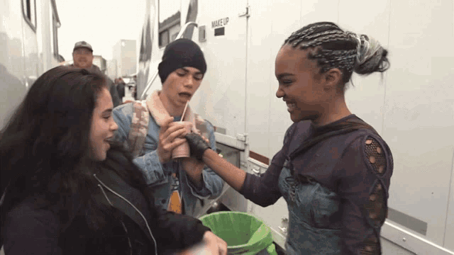 a group of people are standing in front of a trailer that has the word makeup on it