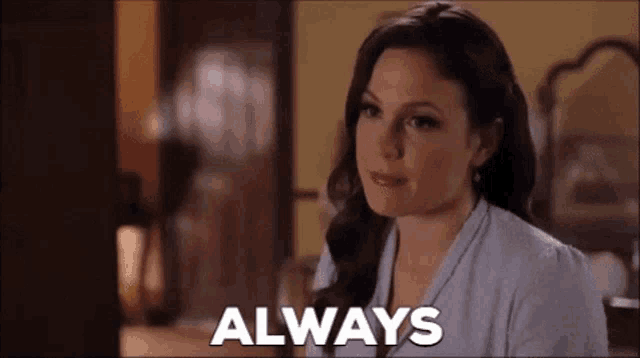 a woman is sitting in a room with the words `` always '' written on the screen .