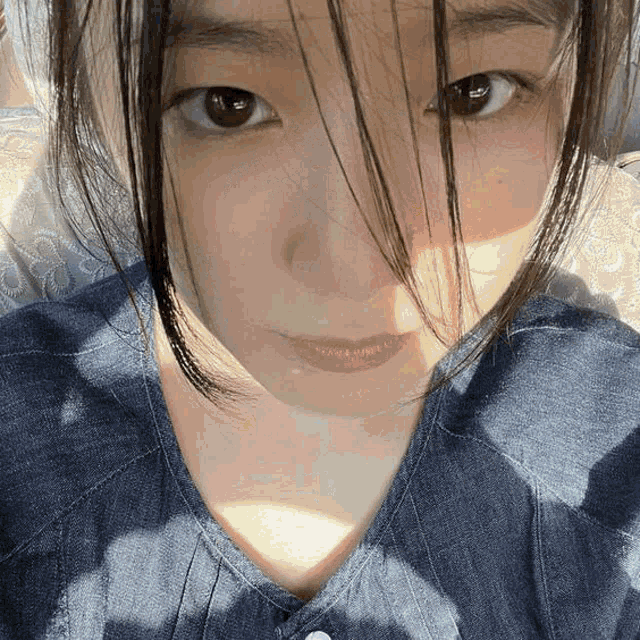 a close up of a woman 's face with the sun shining on it