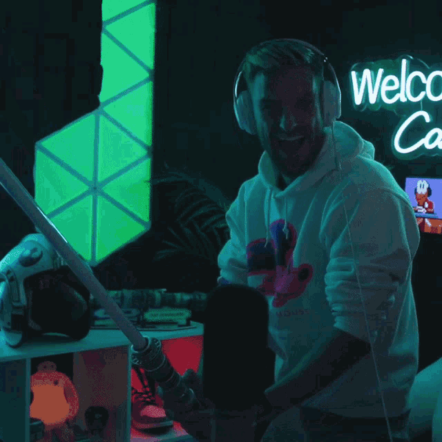 a man wearing headphones is standing in front of a welcome sign