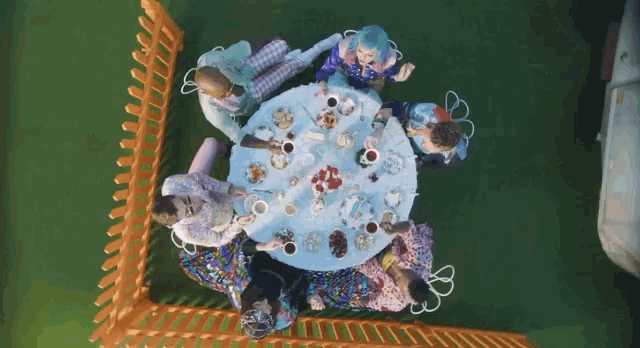 a group of people are sitting around a table with food