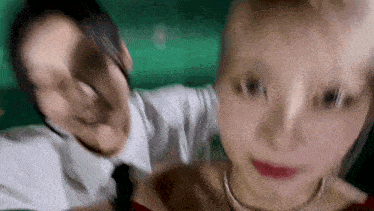 a man and a woman are taking a selfie together in a green room .