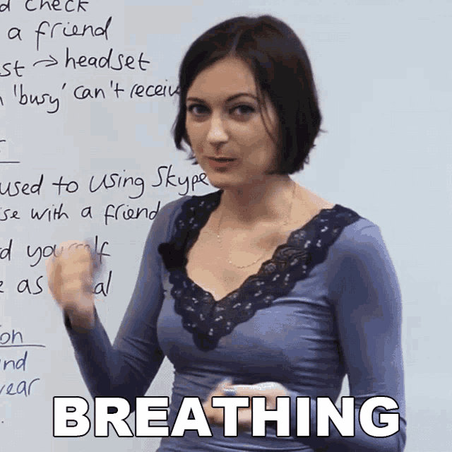 a woman stands in front of a whiteboard with the word breathing written on it