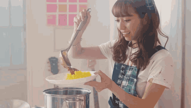 a woman in an apron is holding a plate of food