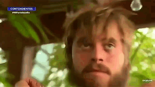 a close up of a man 's face with a beard on a tv screen .