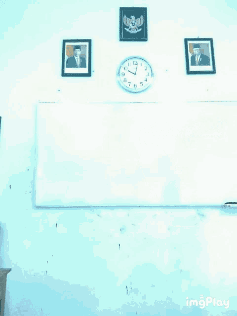 a man stands in front of a white board with a picture of a man on it and a clock on the wall