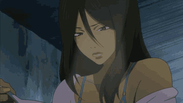 a woman with long dark hair and a purple top is looking down