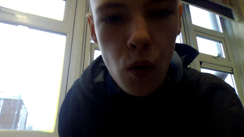 a close up of a person 's face with a window behind them