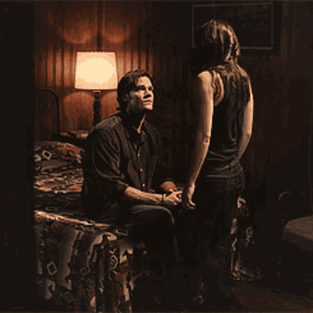 a man and a woman are sitting on a bed