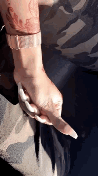 a woman 's arm with a tattoo on it and a watch on her wrist