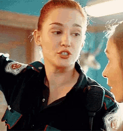 a woman in a uniform is talking to another woman .