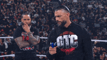 a man wearing a sweatshirt that says uic stands in a wrestling ring