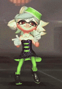 a cartoon character is wearing a green hat and giving a thumbs up while standing on a stage .