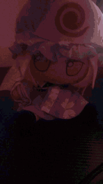a stuffed animal with red eyes and a white hat with a swirl on it